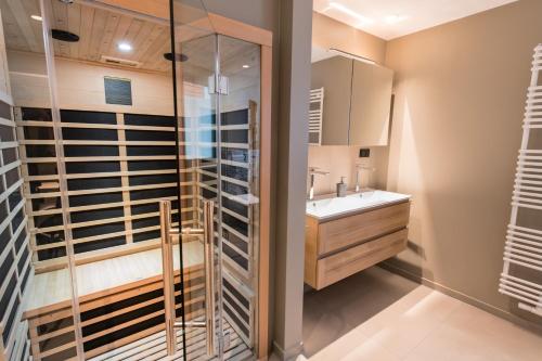 uma casa de banho com um lavatório e uma cabina de duche em vidro. em Ocean House Traum em Timmendorfer Strand