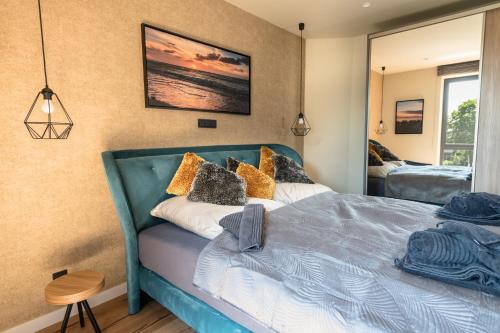 1 dormitorio con cama azul y espejo en Heaven House Harmonie, en Timmendorfer Strand