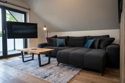 a living room with a couch and a table at Wellness House Relax mit Whirlpool in Timmendorfer Strand