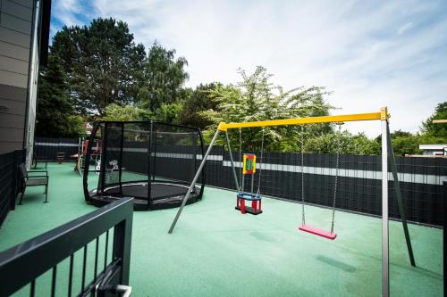 a playground with a swing set on a fence at Heaven House Penthousewohnung Sterngucker mit Whirlpool in Timmendorfer Strand
