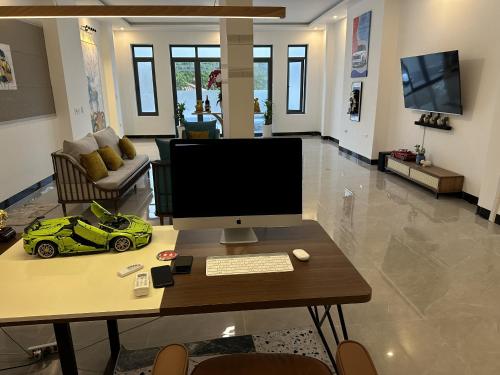 a desk with a computer and a toy car on it at Koi Guest House - Phan Thiết in Ấp Thiện Phước