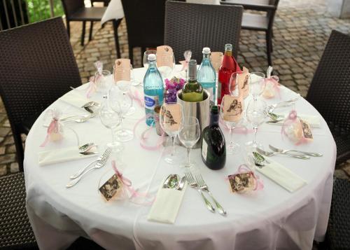 a white table with wine bottles and glasses on it at Berggasthof Hotel Igelwirt in Schnaittach