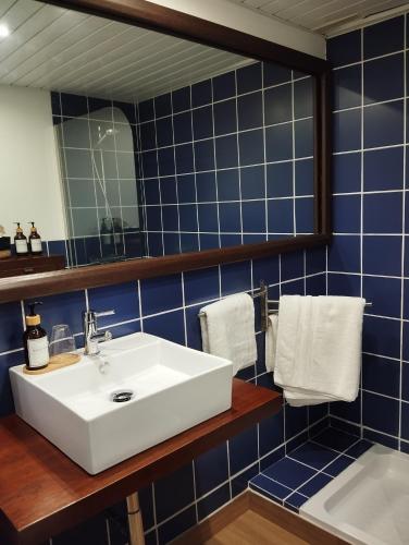 W łazience znajduje się biała umywalka i niebieskie kafelki. w obiekcie Casa Golf49 con parking w mieście Badajoz
