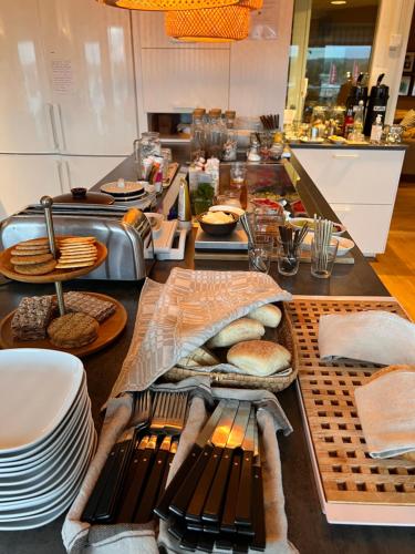 a kitchen counter with plates and bread on a table at Hotell Garvaren in Ljungby