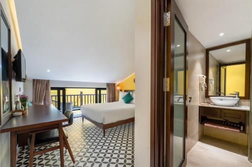 a hotel room with a bed and a bathroom at Villa Soleil Hoi An in Hoi An