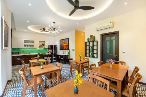 a dining room with wooden tables and chairs at Villa Soleil Hoi An in Hoi An