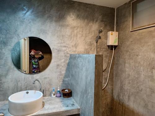 a bathroom with a sink and a mirror at Come Moon Loft Hotel in Phrae