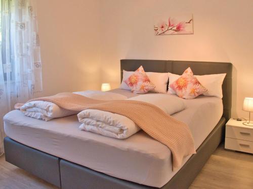 Schlafzimmer mit einem Bett mit rosa und orangefarbenen Kissen in der Unterkunft Ferienhaus Stäffele in Überlingen