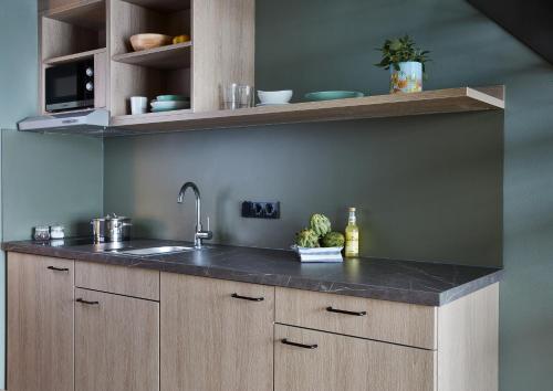 a kitchen with a sink and a counter top at Living Hotel Nürnberg in Nuremberg