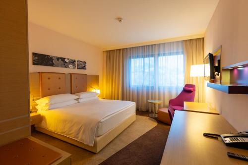 a hotel room with a bed and a desk at DoubleTree by Hilton Oradea in Oradea