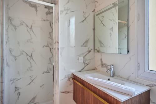 a bathroom with a sink and a mirror at Apartment La Défense by Studio prestige in Puteaux