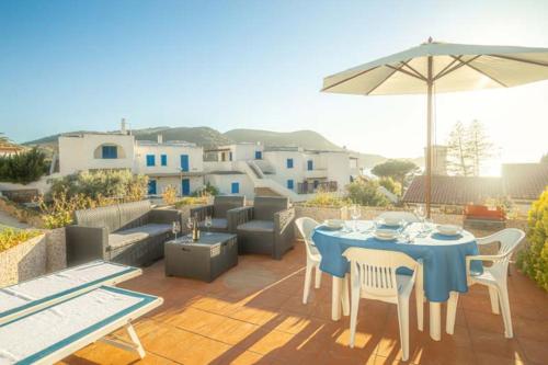 a patio with a table and chairs and an umbrella at Isolella in Campese
