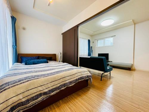 a bedroom with a bed and a chair in it at 3-3札幌駅徒歩8分　美室【サービスアパートメントSAPPORO札幌駅西】エアコン完備 in Sapporo