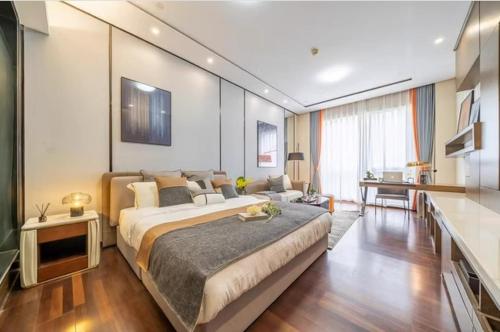 a bedroom with a large bed and a living room at Millenia Executive Apartment - Guangzhou East Railway Station Zhujiang New Town Branch in Guangzhou