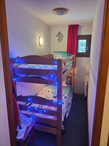 une chambre avec trois lits superposés avec des lumières bleues dans l'établissement appart duplex récent proche des pistes et pioupiou, à Orcières