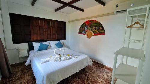 a bedroom with a bed with white sheets and a window at Koh Mak Garden View in Ko Mak