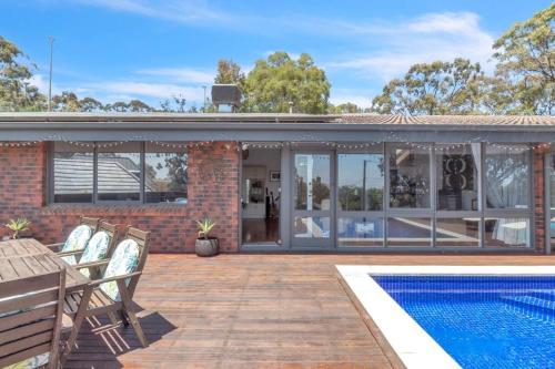 a house with a swimming pool and a patio at Nature's Edge - A Parkland Escape for Families in Adelaide