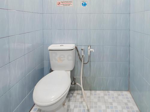 La salle de bains est pourvue de toilettes avec un tuyau. dans l'établissement Griya Tambun Raya RedPartner, à Tumbangrungan