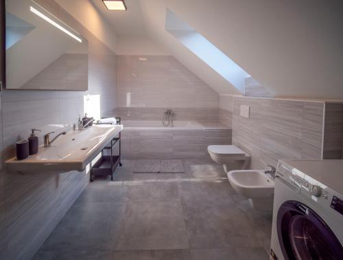 bagno con 2 lavandini, vasca e servizi igienici di Rekreační dům Olomučany a Olomučany