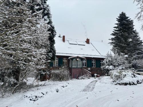 ein schneebedecktes Haus vor einem Hof in der Unterkunft Forsthaus Neudorf in Harzgerode