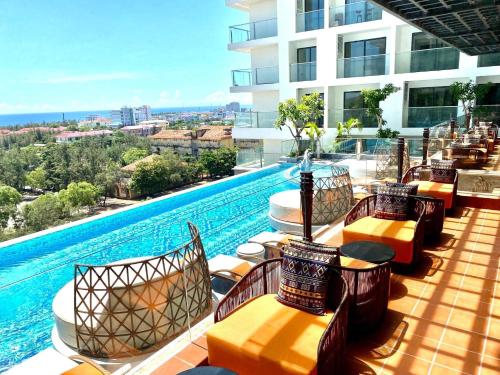 a hotel patio with chairs and a swimming pool at Queen Apec Mandala Phú Yên Condotel in Tuy Hoa