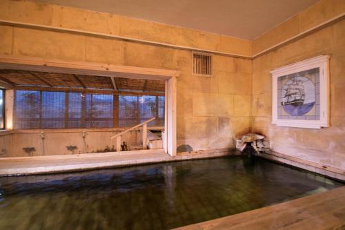 an empty pool in a room with a window at Hotel Housenkaku in Beppu