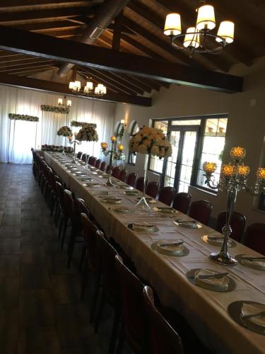 a long table in a room with chairs and flowers at Hotel Rozafa in Dobrosin