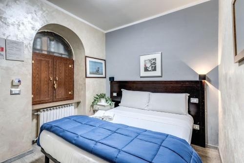 um quarto com uma cama grande e um cobertor azul em Hotel Family House em Roma