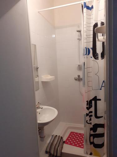 une salle de bain blanche avec un lavabo et une douche dans l'établissement N4 Chambres partagées homme salle de bain et toilette, à Béziers