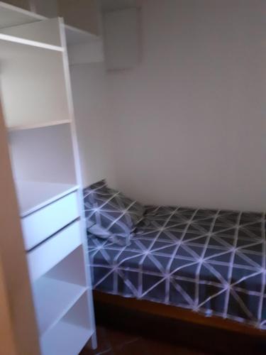 une chambre avec un lit et une étagère dans l'établissement N4 Chambres partagées homme salle de bain et toilette, à Béziers