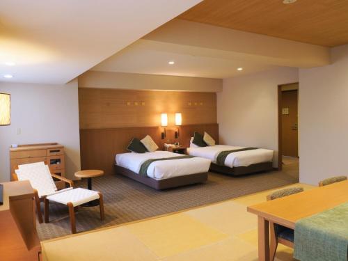 a hotel room with two beds and a table at Yumoto Noboribetsu in Noboribetsu