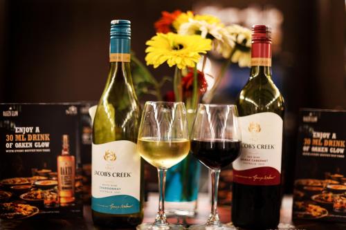 two glasses of white wine next to bottles of wine at Enrise by Sayaji Rewa in Rewa