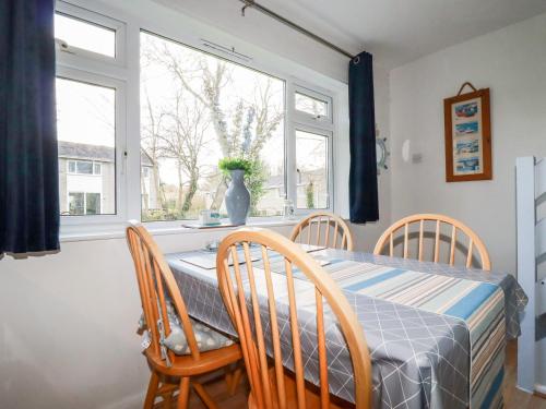 a dining room with a table and chairs and a window at Dolphin Villa in Newquay