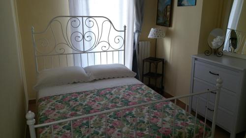 a bedroom with a bed with a floral blanket and a window at Rinaldi's Apartment in Sirolo