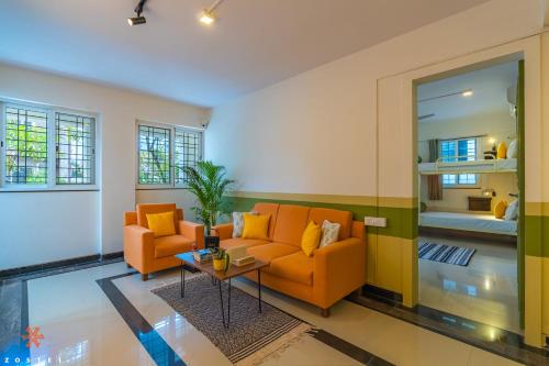 a living room with two orange couches and a table at Zostel Bangalore (Koramangala) in Bangalore