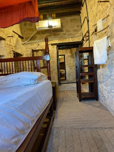 a bedroom with a bed in a stone building at نزل كوفان التراثي Koofan Heritage Lodge in Salalah