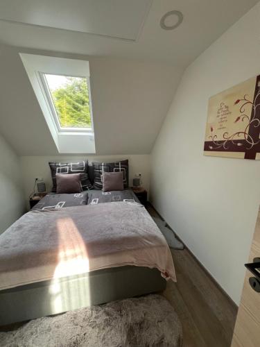 a bedroom with a large bed with a window at Waldheimatblick in Sankt Kathrein am Hauenstein