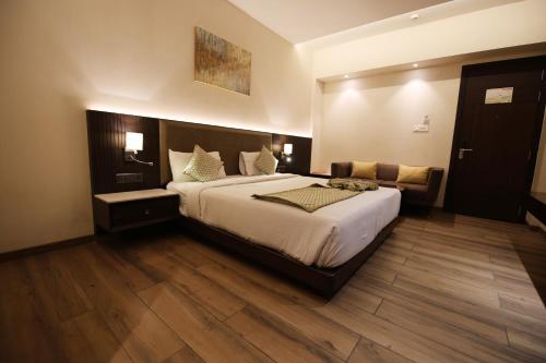a bedroom with a large bed and a couch at Enrise by Sayaji Rewa in Rewa