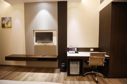 a hotel room with a desk and a television at Enrise by Sayaji Rewa in Rewa