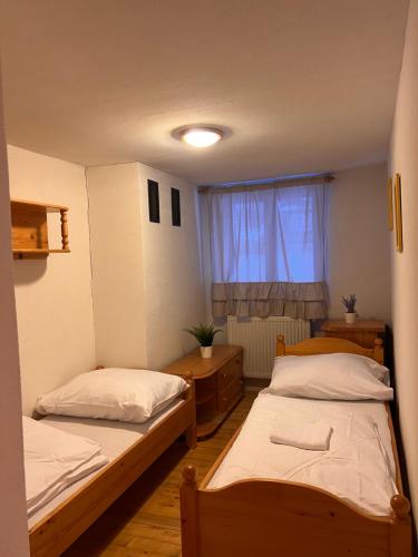 1 dormitorio con 2 camas y ventana en Apartman u Lukyho en Vysoké Tatry