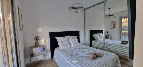 une chambre avec deux lits et un miroir dans l'établissement HOME ET HOLIDAY Le Petit Manseng, à Nice
