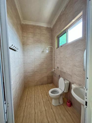 a bathroom with a toilet and a sink at Sunrise Villas in Jambiani