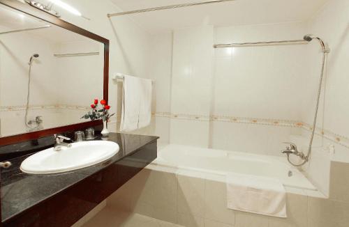 a white bathroom with a sink and a tub at Angella Hotel in Nha Trang