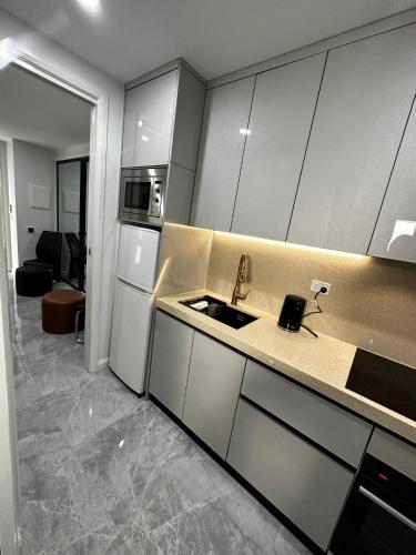 a kitchen with white cabinets and a sink at Executive Suite in Strathnairn