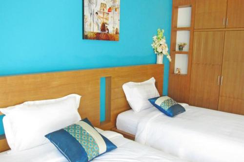two beds in a room with blue walls at Krabi Cinta House in Krabi town