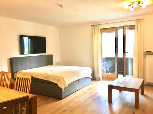 1 dormitorio con 1 cama y TV en la pared en Fewo Isabella en Mittenwald