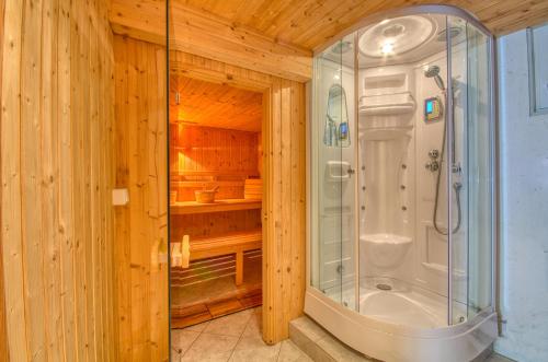 a bathroom with a shower in a wooden wall at Haus Kemp in Zell am See