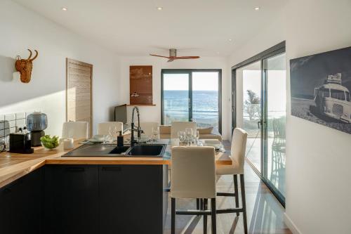 a kitchen and dining room with a table and chairs at Le Moma by the ocean in Trois Bassins