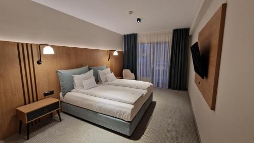 um quarto de hotel com uma cama e uma televisão em Hotel Sorin MIHAI em Brasov