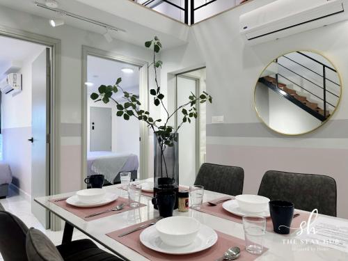 una sala da pranzo con tavolo e specchio di Arte Cheras Luxury Suites by THE STAY HUB a Kuala Lumpur